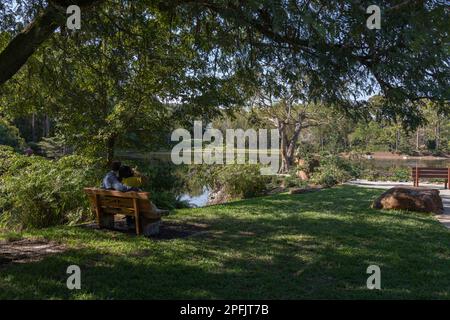 Ein Paar sitzt auf einer Bank im Morikami Museum und japanischen Garten Stockfoto