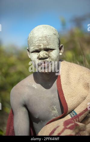 AmaPondo (Xhosa) Junge, eingewickelt in Teppiche mit weißem Lehm (I-Futa) im Gesicht, nach Beschneidung (uku-Lukwa) und nach Beendigung der Initiation, Abgeschiedenheit Stockfoto