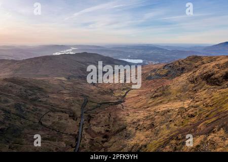 Luftbild einer Drohne mit Blick auf den Sonnenaufgang, Winterblick von Red Screes im Lake District mit Blick auf Windermere in der Ferne über Wansfell Pike Pea Stockfoto