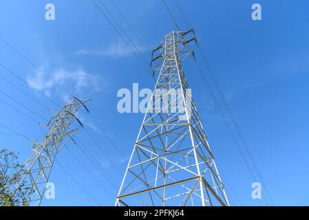 Hochspannungs-Strommasten unter klarem Himmel im Herbst Stockfoto