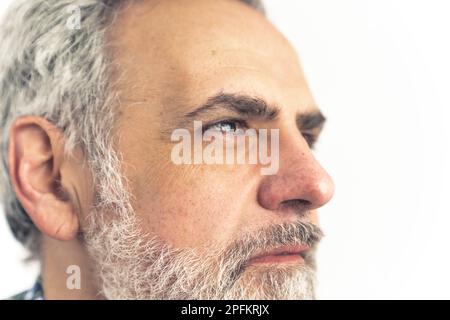 Seitliches Porträt eines grauhaarigen bärtigen Mannes. Nahaufnahme - isoliert auf weißem Hintergrund. Hochwertige Fotos Stockfoto