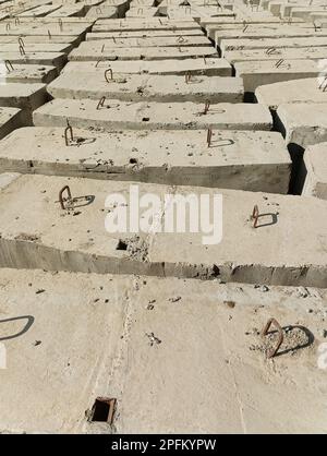 Zementblöcke mit Metallhaken auf der Baustelle Stockfoto