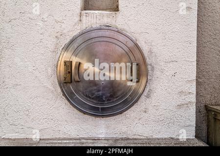Runde Metalltür an der Außenwand eines alten Bankgebäudes Stockfoto
