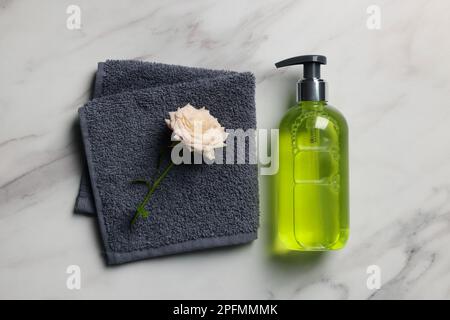 Spender für Flüssigseife, Handtuch und Rose auf weißem Marmortisch, flach liegend Stockfoto