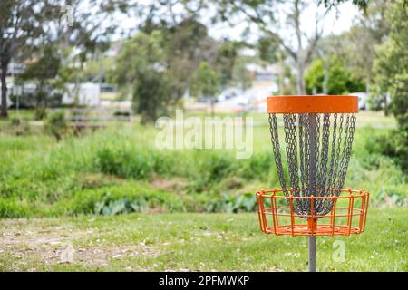 Disc-Golf-Korb (Frolf) in einem Park-Hindernisparcours mit geringer Schärfentiefe Stockfoto