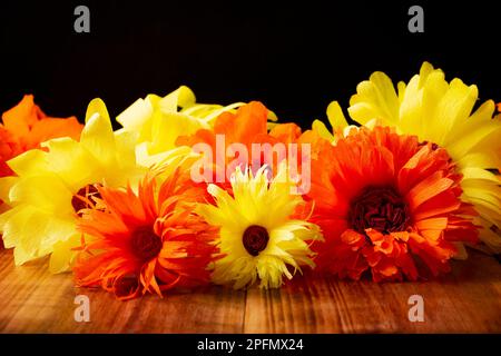 Farbenfrohe Papierblumen auf Holztisch und schwarzem Hintergrund. Dekoration Blumenmuster, Frühling, Ostern, Geburtstag, Happy Womens Day, Muttertag. C Stockfoto