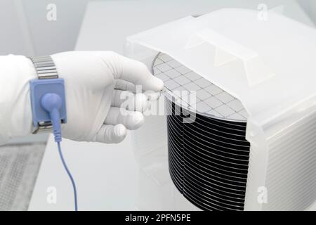 Eine Charge Silizium-Wafer, verpackt in einer Kunststoffbox im Reinraum einer Halbleitergießerei, bereit für die Mikrochip-Produktion. Stockfoto