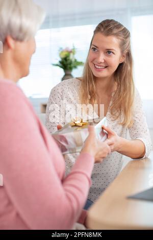 Ältere, schöne Frau mit einer Gabe Stockfoto