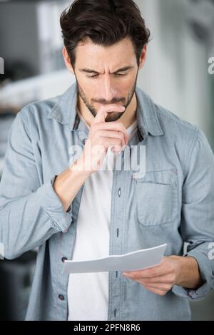 Ein Mann, der Rechnungen ansieht, die er bezahlen muss Stockfoto