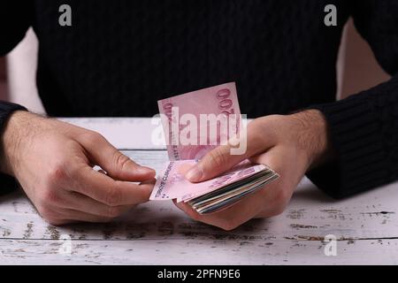 Junger Mann, der türkische Banknoten in der Hand zählt. Türkische Lira TRY oder TL Stockfoto