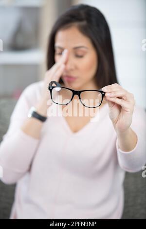 Müde Geschäftsfrau hält Brillen leiden Augenschmerzen Stockfoto