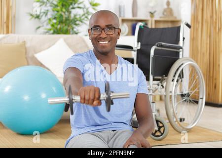 Attraktiver behinderter Querschnittsgelähmter im Rollstuhl beim Rehabilitationssport Stockfoto