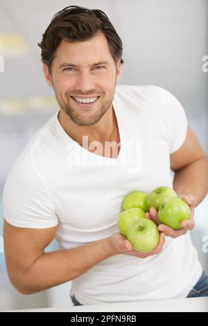 Grüner Apfel in einer männerpalme Stockfoto