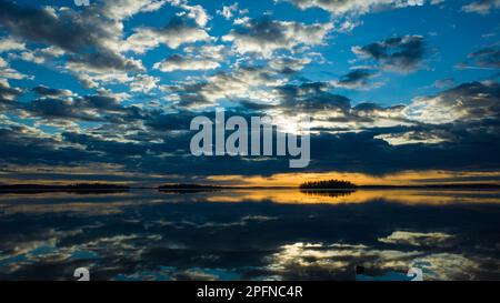 Morgenlicht im Malarsee in Schweden, Himmel reflektiert in ruhigen Wasser dramatische Wolken, Goldener Horizont mit dunkler Silhouette von Inseln, Scand Stockfoto