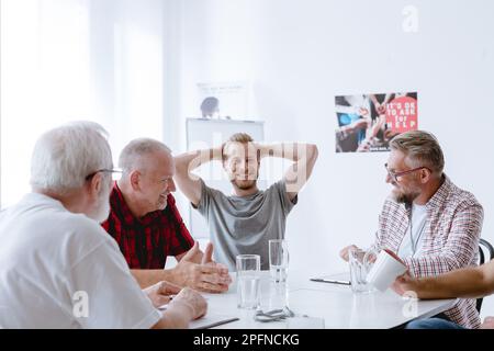 Während der Gruppenpsychotherapie entdecken Männer ihre Hoffnungen, Ängste, Verluste, Frustrationen und Traumata Stockfoto