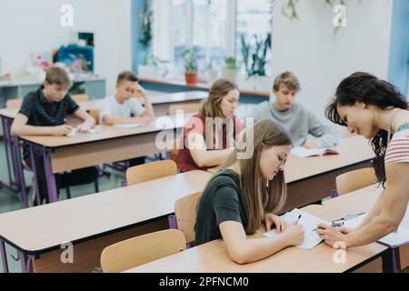 Junger Lehrer und Schüler im Unterricht Stockfoto