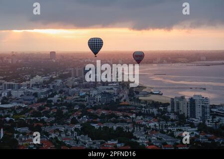 Zwei Heißluftballons fliegen über Port Melbourne bei Sonnenaufgang, Victoria, Australien Stockfoto