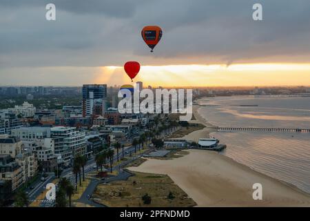 Drei Heißluftballons fliegen über Port Melbourne bei Sonnenaufgang, Victoria, Australien Stockfoto