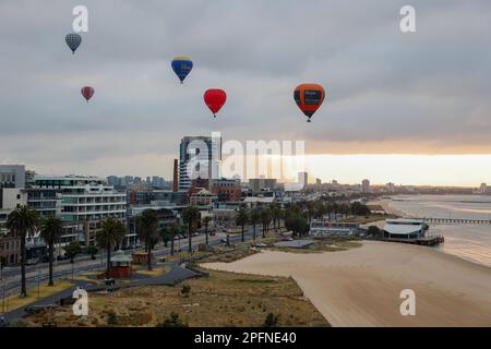 Heißluftballons fliegen über Port Melbourne bei Sonnenaufgang, Victoria, Australien Stockfoto
