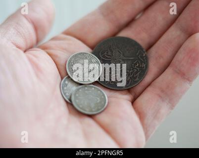 Eine alte Silber- und Kupfermünze aus dem Osmanischen Reich. Ein Mann, der sich in der Hand hält Stockfoto