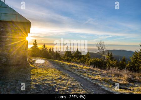 Ein frostiger, sonniger Morgen mit Sonnenstrahlen, die durch einen Steinunterschlupf im Jeleni studanka im Hruby-Jesenik-Gebirge in der Tschechischen Republik scheinen Stockfoto