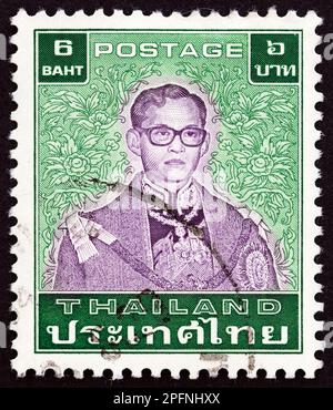 THAILAND - CIRCA 1984: Ein in Thailand gedruckter Stempel zeigt König Bhumibol Adulyadej, circa 1984. Stockfoto