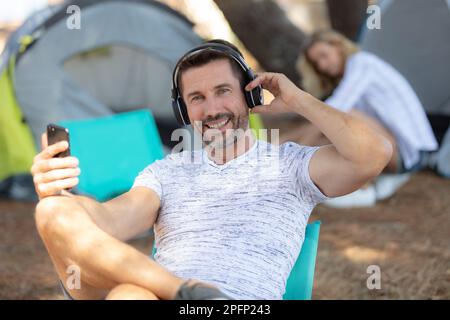 Der Mann beim Camping liebt Musik Stockfoto