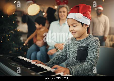 Junge, Musiktastatur und weihnachten im Familienhaus mit Lächeln, Spielen und kreativen Fähigkeiten mit Großmutter. Männlicher Junge, junger Musiker und Großeltern Stockfoto