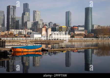 Mit Blick auf Millwall Dock in Richtung Docklands und South Quay. Das ruhige Wasser der Anlegestelle steht im Kontrast zum hohen Wohnviertel dahinter. Stockfoto