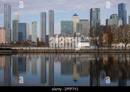 Blick auf die Skyline der Isle of Dogs vom Millwall Dock mit mehreren Wohn- und Bürohochkratzen, mit Reflexionen auf dem Wasser. Stockfoto