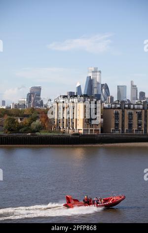 Ein Raketenboot auf der Themse beschleunigt die Themse. Passagiere auf einer aufregenden Flussfahrt zu befördern. Dahinter befinden sich die Gebäude der City of London. Stockfoto