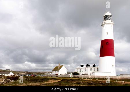 Portland Bill Lighthouse. Auf der Isle of Portland steht der imposante rot-weiße Leuchtturm. Inmitten einer Landschaft mit umliegenden Gebäuden gelegen. Stockfoto