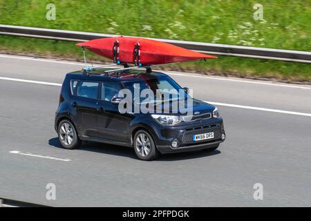 2016 Black Kia Soul Connect CRDI, mit Kanu am Dachgepäckträger befestigt; Fahrt auf der Autobahn M61, Großbritannien Stockfoto