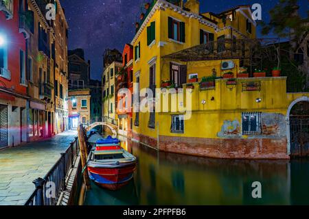 Romantische Straßen und Kanäle von Venedig bei Nacht. Farbenfrohe Häuser und Boot auf dem Kanal. Beliebtes Reiseziel in Europa Stockfoto