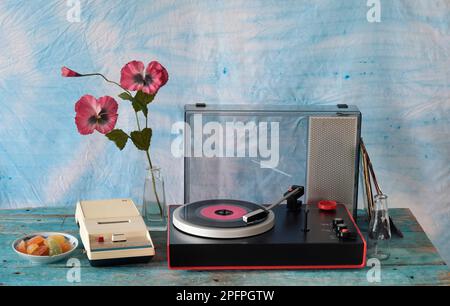 Klassischer Plattenspieler mit violetter Schallplatte, Lautsprecher und altem Kassettenrekorder, Stilleben in den 70er Jahren Stockfoto