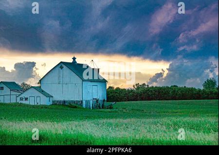 Ein Sturm zieht über einem Bauernhaus auf einer Farm in Minnesota herüber. Stockfoto