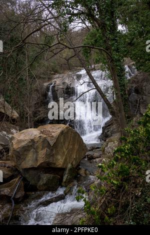 Las Nogaledas Wasserfall in Valle del Jerte vertikal mit einem großen Felsfall im Vordergrund Stockfoto