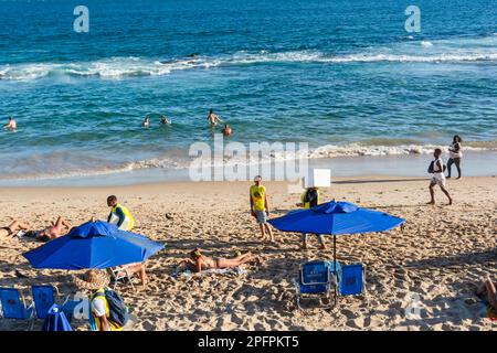 Salvador, Bahia, Brasilien - 22. Oktober 2022: Menschen, die sich an einem heißen Tag im Praia do Farol da Barra entspannen. Salvador, Bahia. Stockfoto