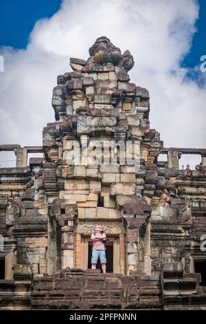 Ein Touristenmann steht auf der Treppe in Angkor Wat in Kambodscha. Stockfoto