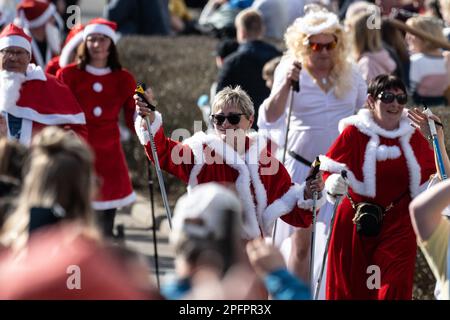 Eisenach, Deutschland. 18. März 2023. Während des traditionellen Eisenach Sommergewinn-Wettbewerbs fahren die Teilnehmer in Laufgruppen durch die Stadt. Nach einem alten Brauch wird der Winter in Eisenach während des Sommergewinn, eines der ältesten und größten Frühlingsfestivals Deutschlands, verjagt. Kredit: Swen Pförtner/dpa/Alamy Live News Stockfoto