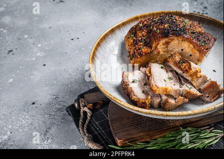 Philippinisch marinierter Schweinebauch mit Kruste auf einem Teller. Grauer Hintergrund. Draufsicht. Speicherplatz kopieren. Stockfoto