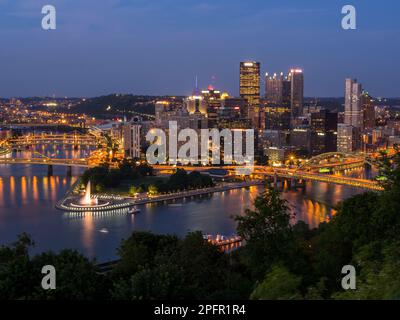 Downtown Pittsburgh Skyline bei Nacht mit Flüssen, Brücken und dem Brunnen im Point State Park. Stockfoto