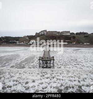 Ein Luftblick von der Nordsee auf das viktorianische Gebäude von Saltburn am Sea Pier, 2. Weltkulturerbe, mit brechenden Wellen Stockfoto