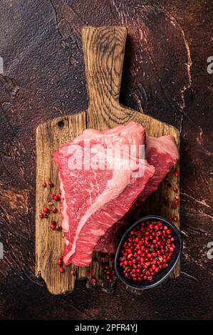 Rohes Filet-Rindfleisch, Silverside-Steak auf einem Holzbrett. Dunkler Hintergrund. Draufsicht. Stockfoto