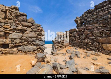 Aus nächster Nähe bietet sich ein historischer Blick auf die Karibikküste mit Ruinen der Goldschmelze in Bushiribana. Aruba. Stockfoto