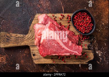 Rohes Filet-Rindfleisch, Silverside-Steak auf einem Holzbrett. Dunkler Hintergrund. Draufsicht. Stockfoto