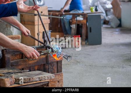 Traditioneller Glasbläser, der Flüssigglas formt Stockfoto