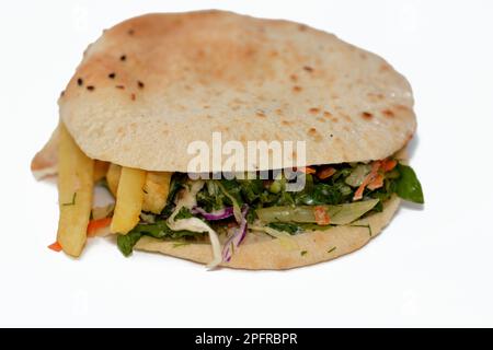 Flat Shami Syrian Bread gefüllt mit pommes Frites und grünem Salat, traditionelle ägyptische frittierte Kartoffeln Finger Sandwich umgeben von kühlen und knusprigen umgeben Stockfoto