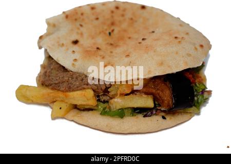 Mischung aus Kartoffeln, gebratenen Fingern, pürierten Fava-Bohnen, gebratener Aubergine, ägyptischem Falafel-grünen Burger, gekochten Eiern und Tahini gefüllt in einem Shami flatbre Stockfoto