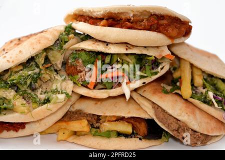 Traditionelle ägyptische beliebte Frühstückssandwiches mit pürierten Fava-Bohnen, gebratenen knusprigen Falafel-Bällen, gebratenen Kartoffeln, Moussaka in Shami-Brot und Stockfoto